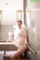 A woman in a wedding dress sitting in front of a mirror.