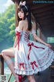 A woman in a white dress and red shoes sitting on a porch.