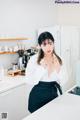 A woman standing in a kitchen next to a counter.