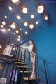 A woman standing on a set of stairs in a room.